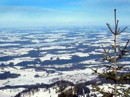 Gipfelblick auf den Chiemgau, in der Mitte der teils zugefrorene Simssee.